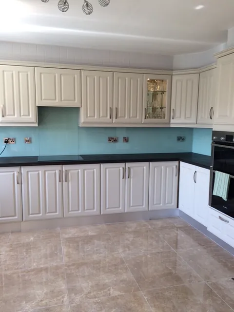 Blue kitchen splashback in a large kitchen with white cupboards