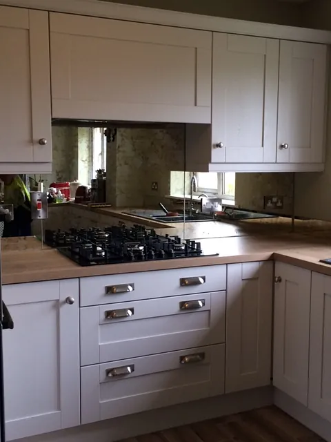 Mirror glass splashback in a traditionally designed kitchen